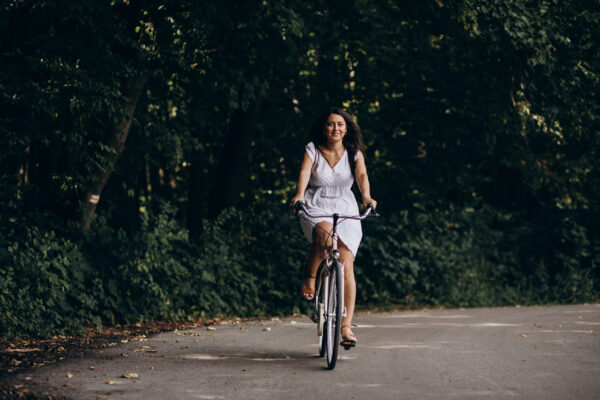 woman-in-dress-riding-bicycle-in-park